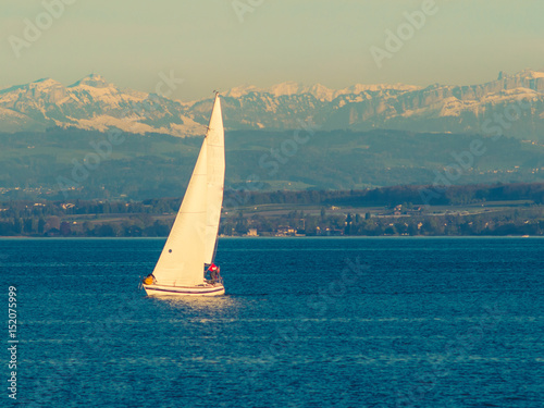 Sailing boat on a lake with Alps in background