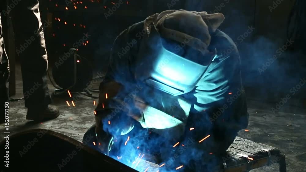 worker welds metal parts