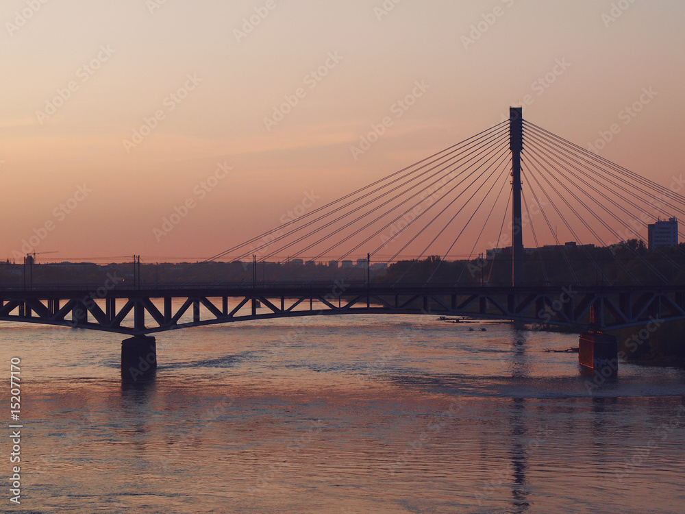 Obraz premium Vistula river and bridge at sunset in Warsaw, Poland. 