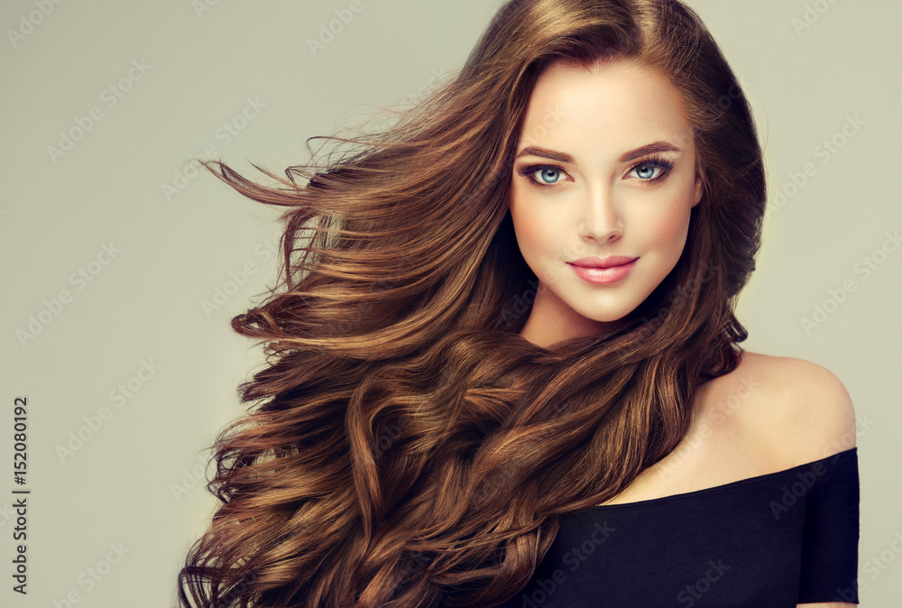 Brunette girl with long and shiny wavy hair . Beautiful model with curly  hairstyle . Stock Photo | Adobe Stock
