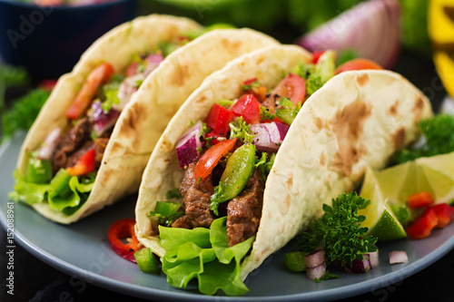 Mexican tacos with beef in tomato sauce and salsa