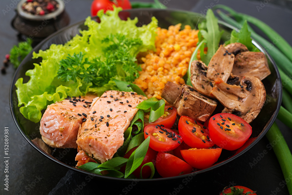 Healthy salad with salmon, tomatoes, mushrooms, lettuce and lentil on dark background Healthy salad with salmon, tomatoes, mushrooms, lettuce and lentil on dark background