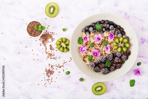 Tasty and healthy oatmeal porridge with fruit, berry and flax seeds. Healthy breakfast. Fitness food. Proper nutrition. Flat lay. Top view photo