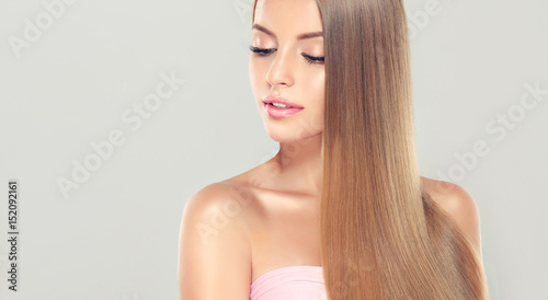 Beautiful model girl with shiny blonde  straight long  hair . Care and hair products .
