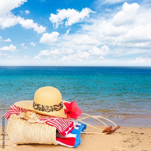 sunbathing accessories on beach in straw bag, summer relaxation and vacations concept