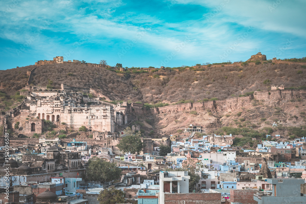 Bundi cityscape, travel destination in Rajasthan, India. The majestic fort perched on mountain slope overlooking the blue city.