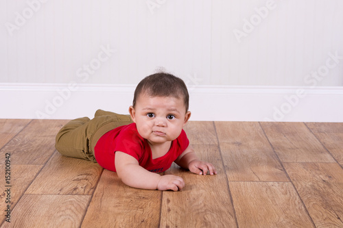 Adorable baby boy laying on the floor
