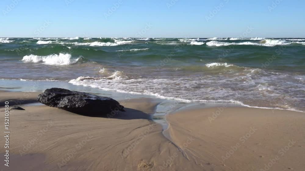 Waves wash up on the beach with drift wood Waves wash up on the beach with drift wood