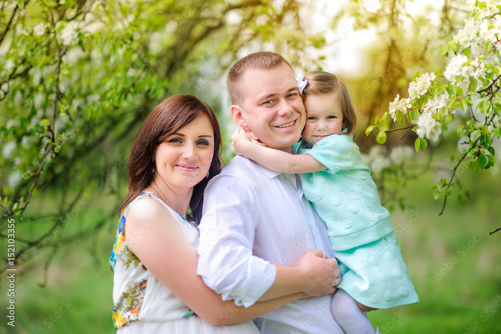 happy family walks in the park on a sunset, stand under the blossoming tree and embrace happy family walks in the park on a sunset, stand under the blossoming tree and embrace