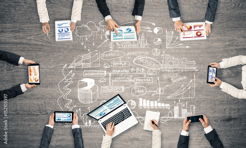 Top view of businesspeople sitting at table and using gadgets