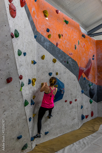 Girl climbing a boulder wall