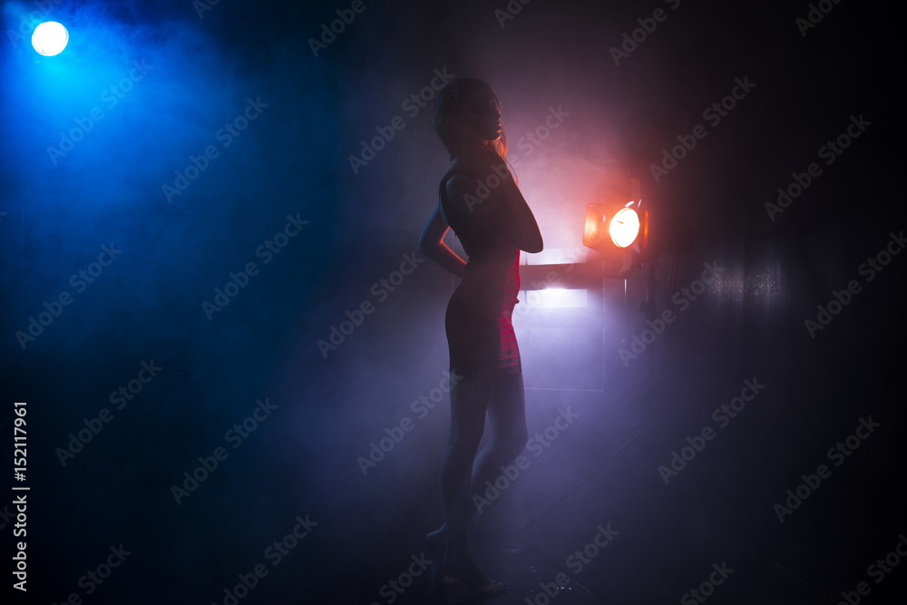 the girl's silhouette in fog against the background of light sources