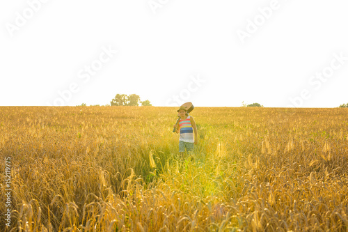 Musician holding acoustic guitar and walking in summer fields at sunset. © satura_