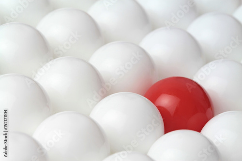 Difference concept, red ball in white balls. Conceptual image.
