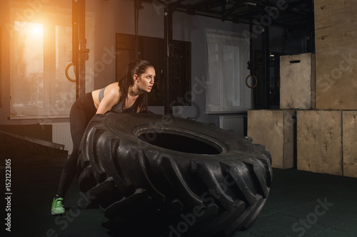 Cuadro en lienzo Fit female flipping tire at the gym.