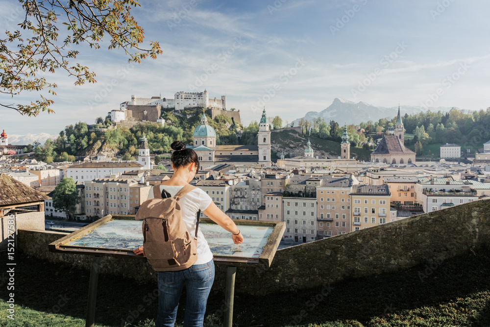 Austria. Salzburg. The girl tourist on the observation deck at the old maps of the city with views of the Hohensalzburg fortress