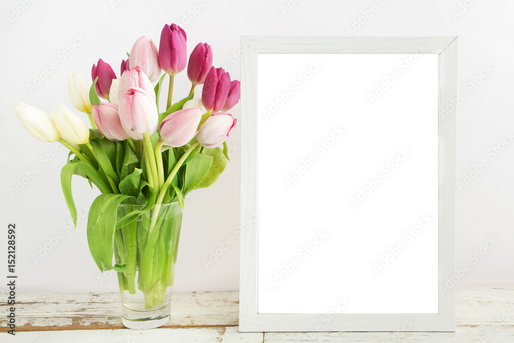 Tulip with blank picture frame on white wooden table Tulip with blank picture frame on white wooden table