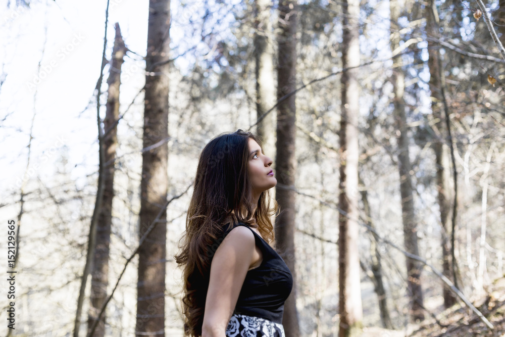 Portrait of beautiful woman in a forest, she is looking towards the sky Portrait of beautiful woman in a forest, she is looking towards the sky