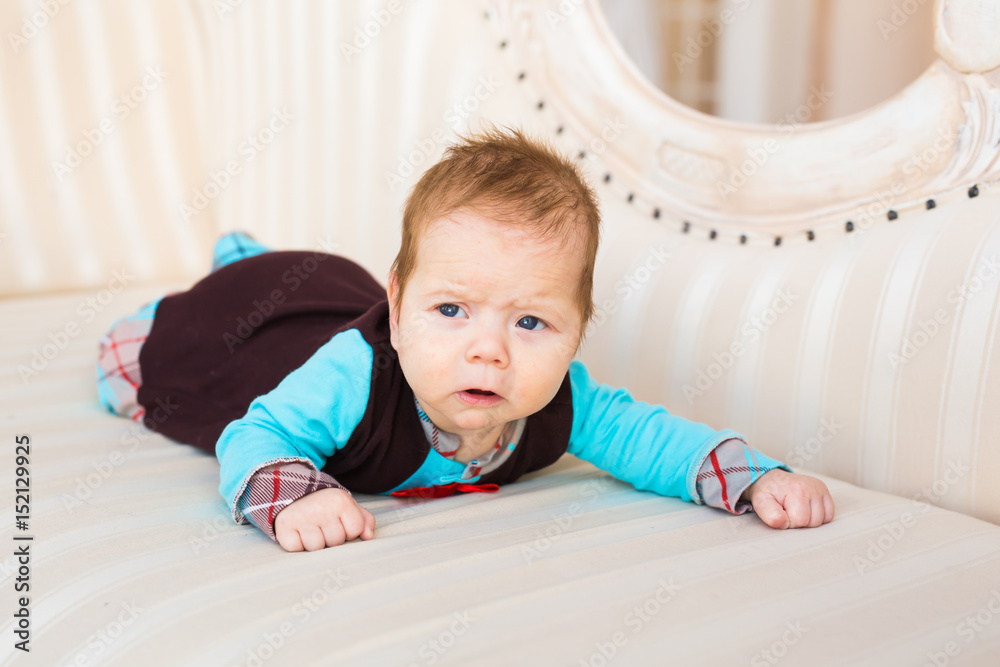 Close-up portrait of baby boy with red hair and blue eyes. Newborn child lyling in couch. Close-up portrait of baby boy with red hair and blue eyes. Newborn child lyling in couch.