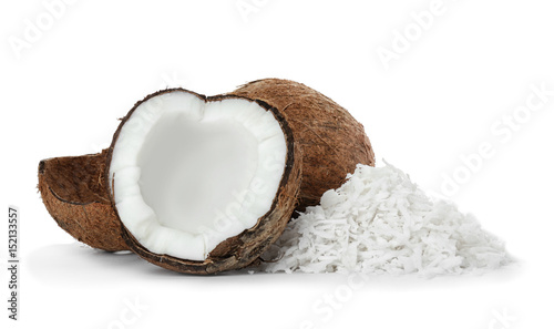 Heap of coconut flakes and fresh nut on white background