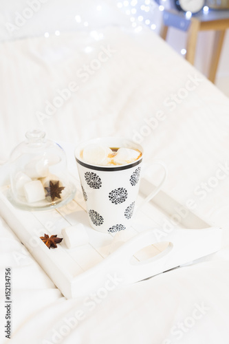 Breakfast in bed - tray with cup of coffee and marshmallows, cozy hygge home style