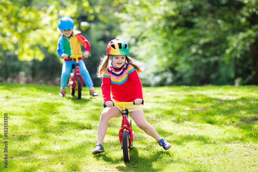 Fototapeta premium Kids ride balance bike in park