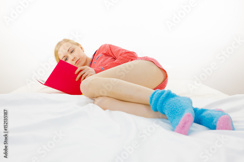 Woman relaxing in bed reading book