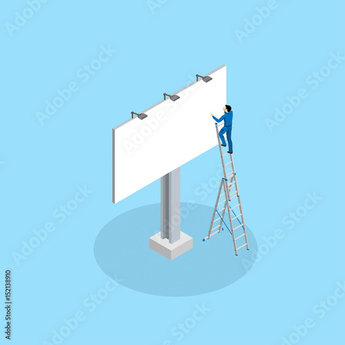 The advertising worker glues the billboard standing on the mounting ladder