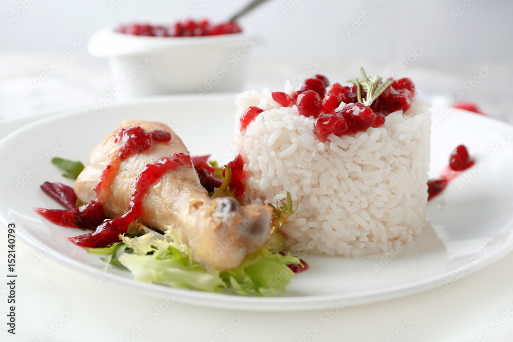 Portion of rice and chicken with cranberry sauce on plate Portion of rice and chicken with cranberry sauce on plate