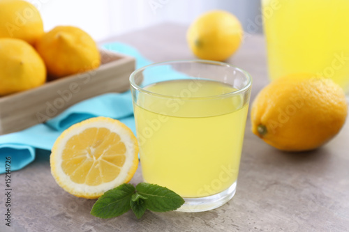 Delicious lemon juice in glass on kitchen table