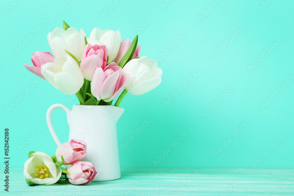 Bouquet of tulips in jug on green background Bouquet of tulips in jug on green background