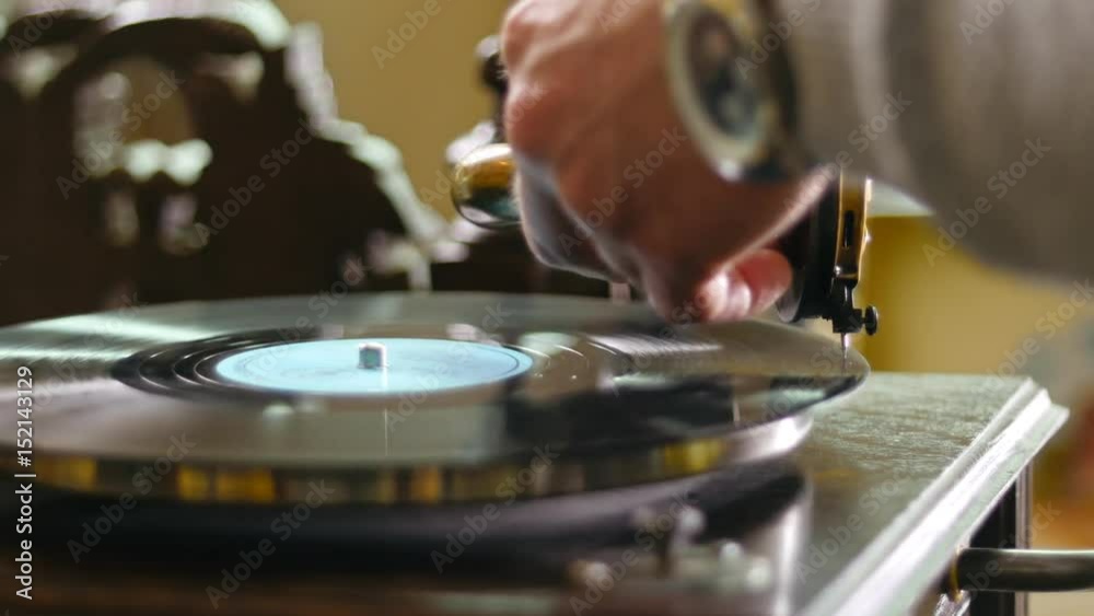 Hand of man putting vintage gramophone in starting position