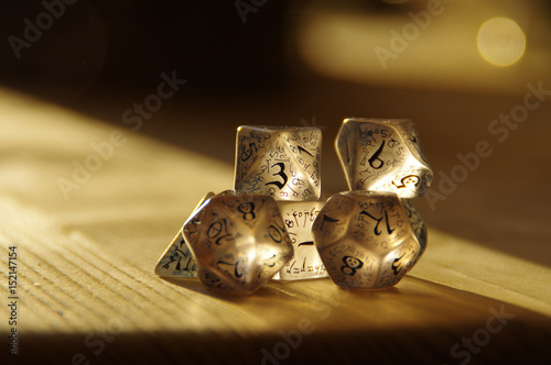 Few transparent rpg dice on table highlighted by the sun. D&D - Dungeons and dragons. photo