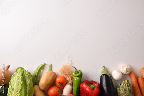 Vegetables lined up on white table top view