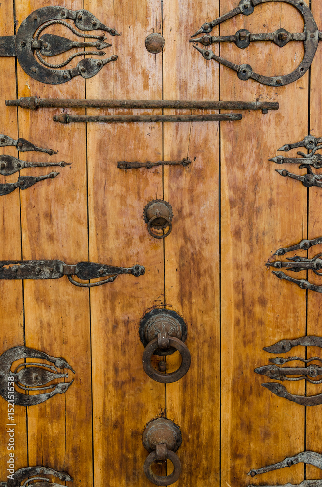 Ancient rusting wooden door with metal fittings, handles and ornaments at historic building in old town Fez, Morocco Ancient rusting wooden door with metal fittings, handles and ornaments at historic building in old town Fez, Morocco