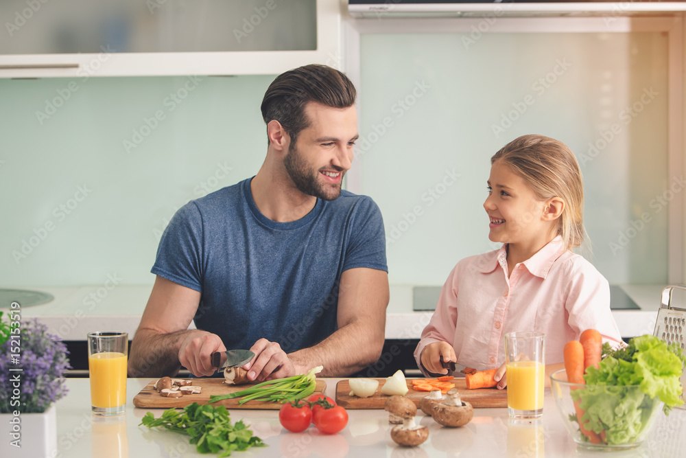 Young father and daughter cooking meal together 