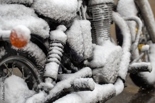 Motorcycle covered with snow. Sharp cooling, climate change. Unsuccessful time for riding a motorcycle.