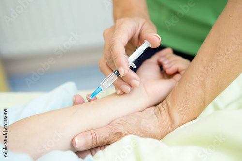 Brave little girl receiving injections by her pediatrician