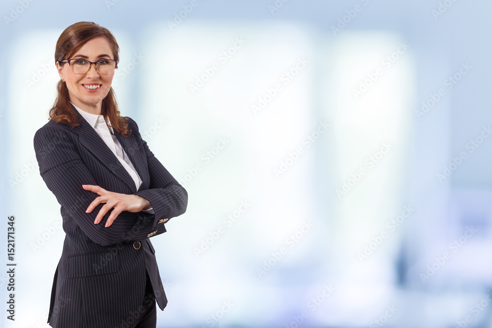Portrait of a beautiful businesswoman 50 ears old in crossed arms pose in the office. Portrait of a beautiful businesswoman 50 ears old in crossed arms pose in the office.