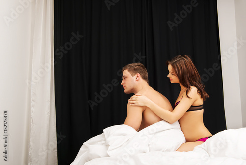 Unhappy young couple in bedroom.