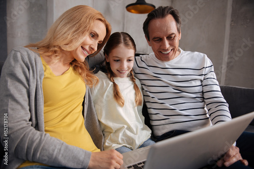 Amused family using laptop at home