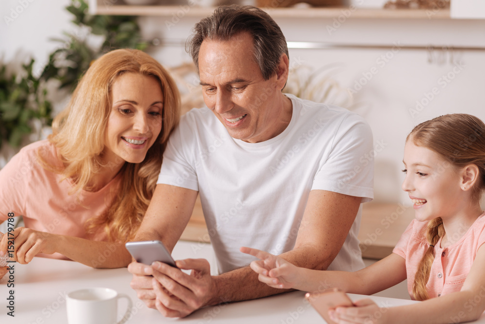 Happy family using electronic gadget and surfing the Internet indoors Happy family using electronic gadget and surfing the Internet indoors