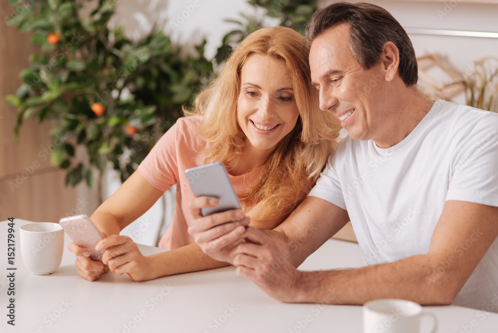 Cheerful couple using digital gadgets at home Cheerful couple using digital gadgets at home