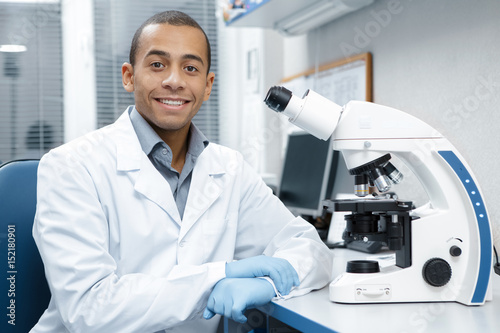 Professional male scientist working on his microscope at the lab