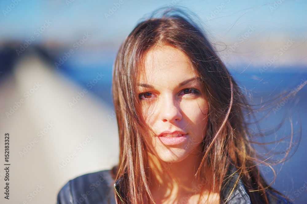 Portrait of a young pensive girl with long waving in wind hair looking at camera with big sad eyes, on blurred background, close up. Portrait of a young pensive girl with long waving in wind hair looking at camera with big sad eyes, on blurred background, close up.