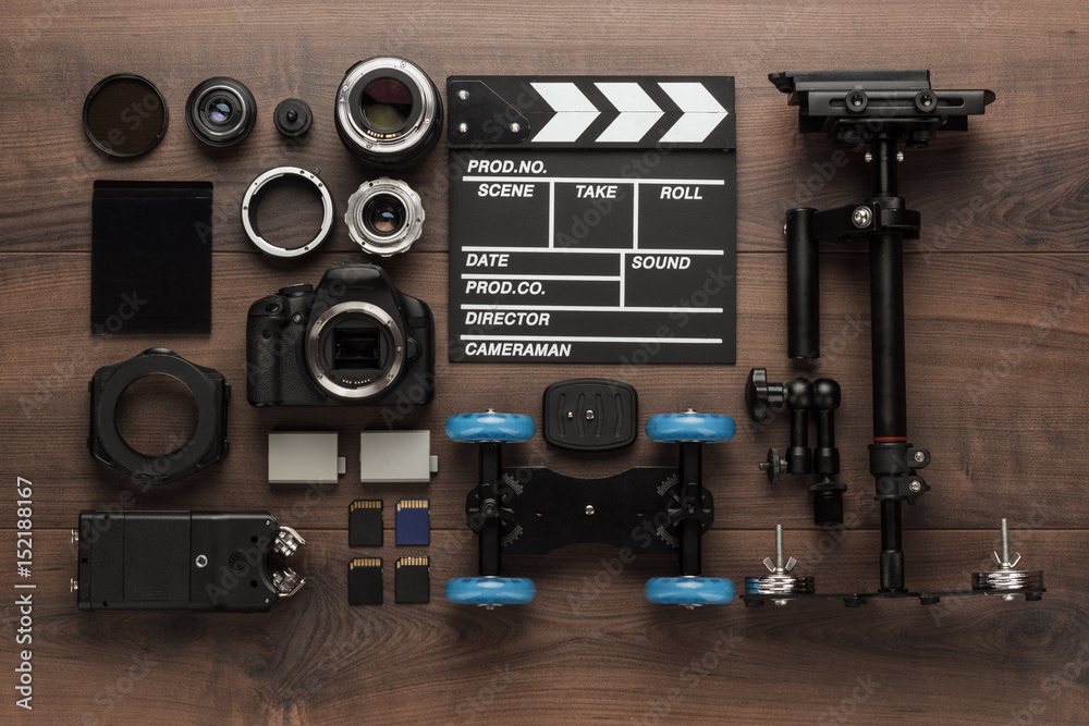 Naklejka premium different video making equipment for indie production on brown wooden table view from above. short movie production essentials