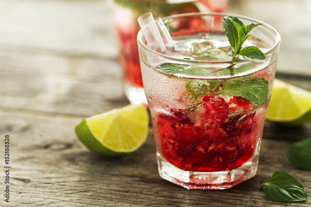 Tasty cold fresh drink lemonade with raspberry, mint, ice and lime in glass. Closeup. Tasty cold fresh drink lemonade with raspberry, mint, ice and lime in glass. Closeup.