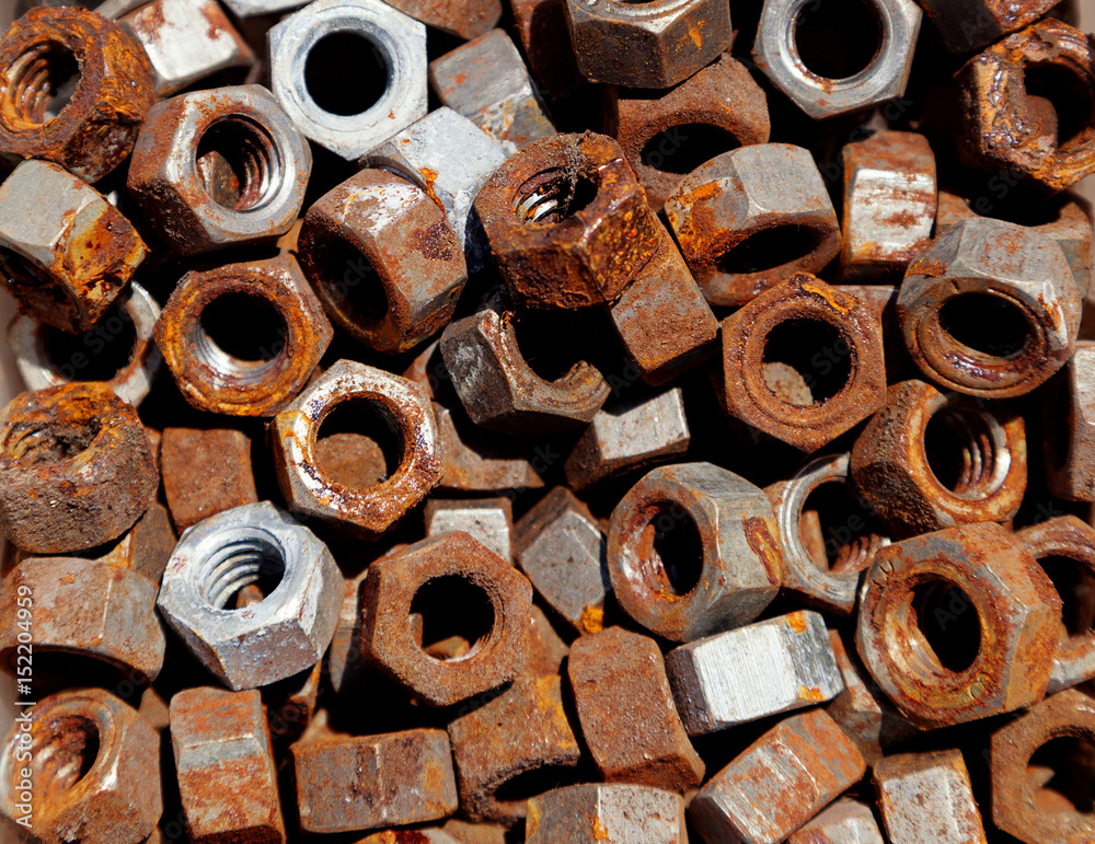 Background of rusty used bolts in different shapes and sizes with space for text.