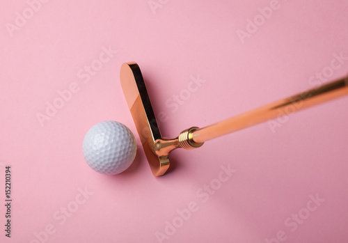 Obraz luksusowy złoty kij golfowy w pobliżu piłeczki do golfa na różowym tle