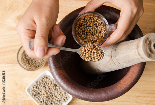 Photos Coriander seed pounding in mortar prepare for Thai food cooking